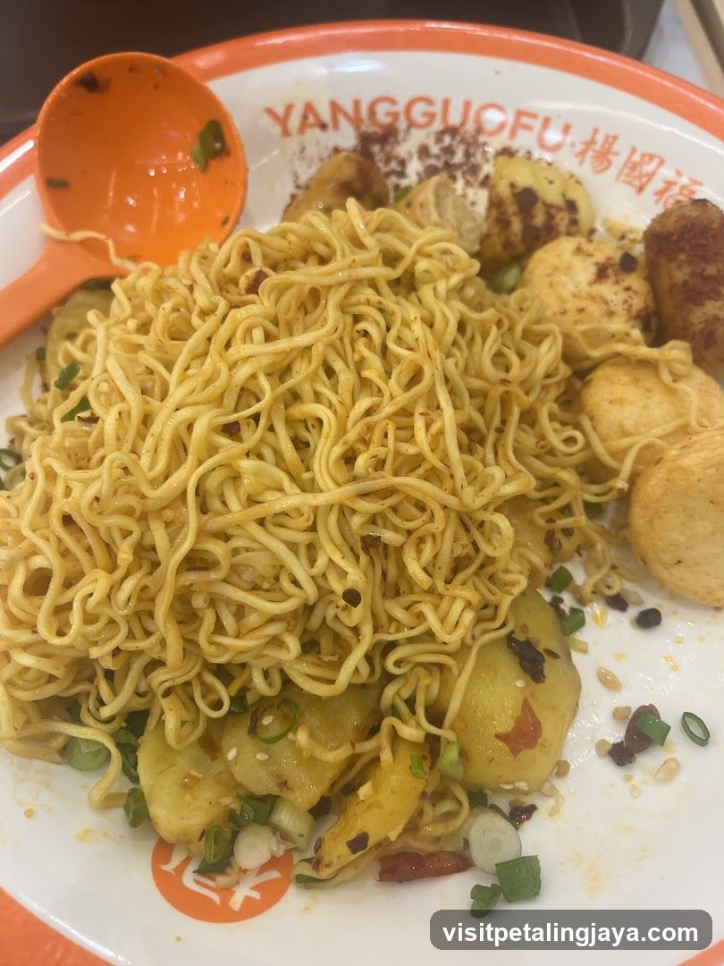 Noodle dish with fried potatoes and garnishes