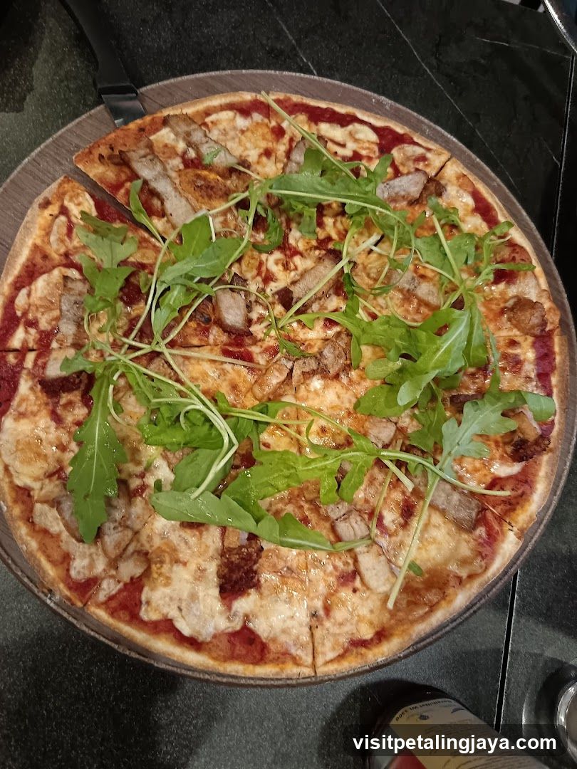 Pizza with arugula and meat toppings