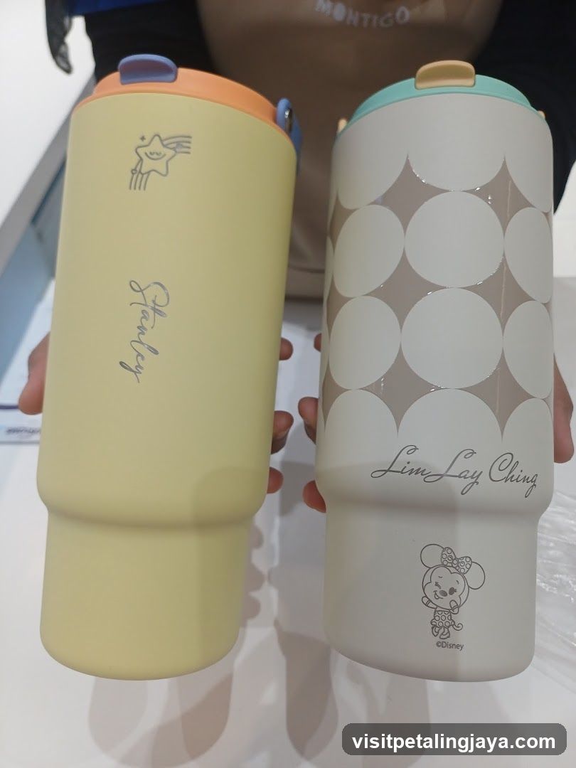 Two branded water bottles held by person