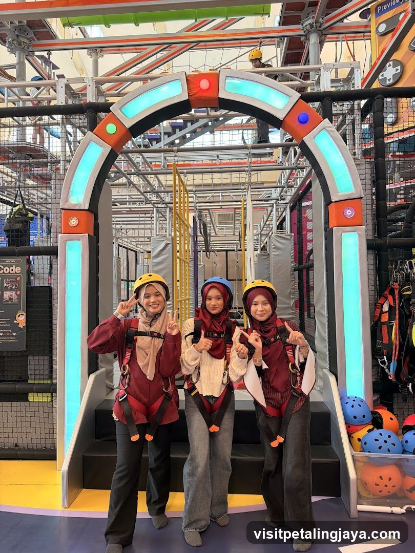 Three individuals posing in an indoor adventure park