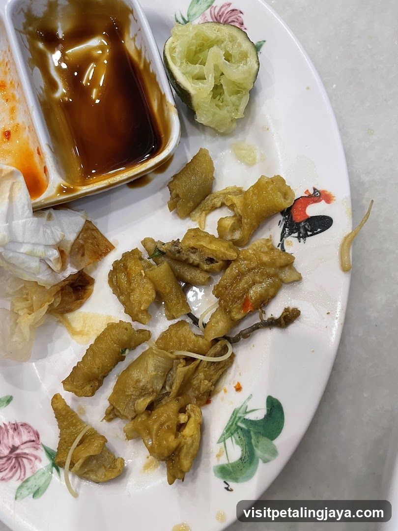 Plate of food remnants with sauce and cucumber