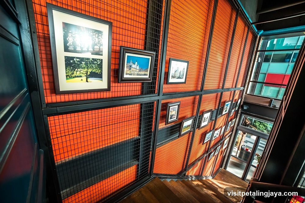 Staircase with Orange Grid Wall and Framed Photos