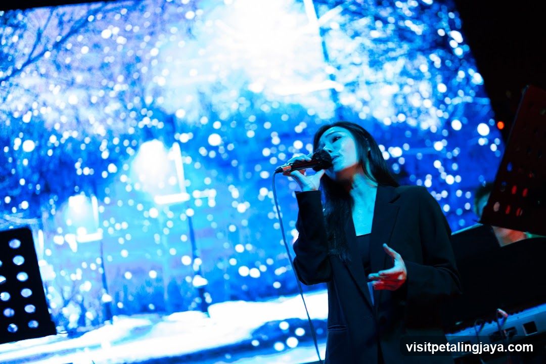 Singer performing on stage with blue lighting backdrop