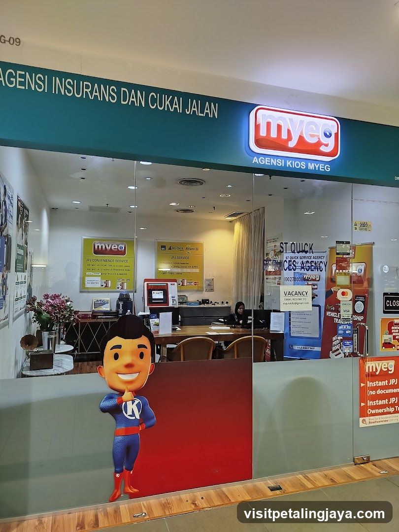 A storefront of myeg agency kiosk with visible signage reading 'AGENSI INSURANS DAN CUKAI JALAN' and the myeg logo. The entrance features glass doors, a cartoon character cutout on the window, and various posters inside including one mentioning 'ST QUICK SERVICE AGENTS'. There is also a 'VACANCY' sign posted near the door.