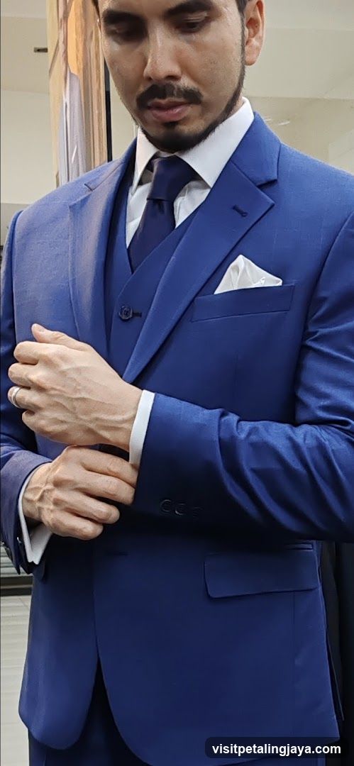 Man in Blue Suit Adjusting Cufflinks