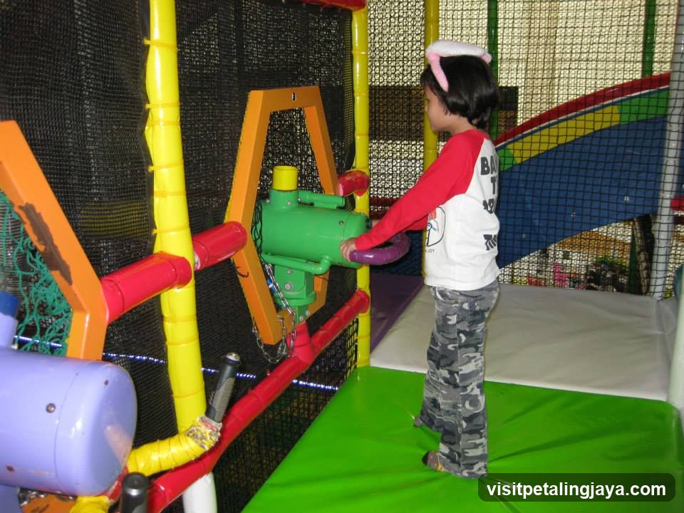 Child Playing with Toy Gun in Indoor Play Area