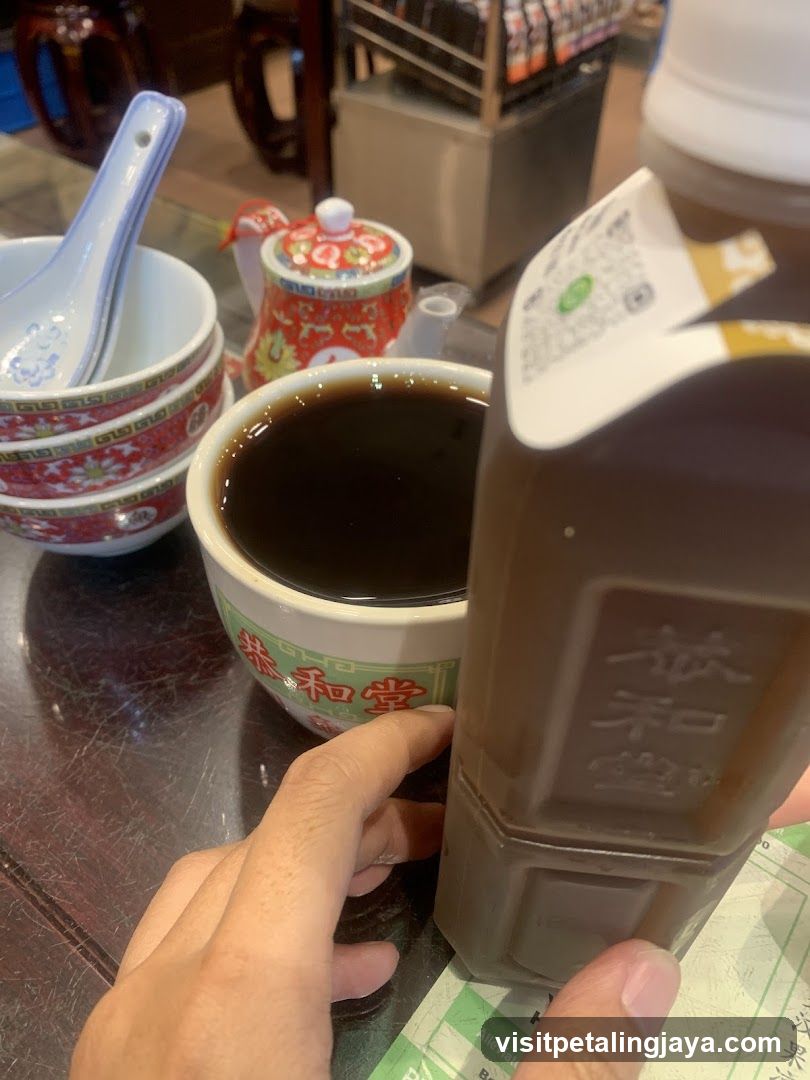 Bowl of dark liquid with condiment bottle