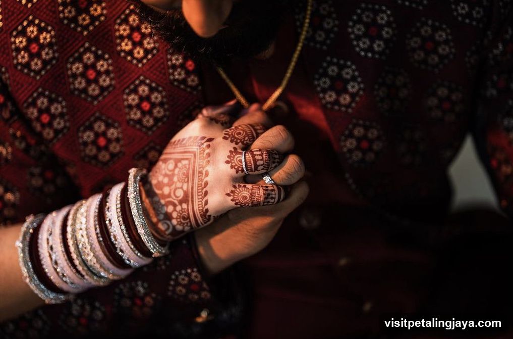 Henna-Adorned Hands Holding a Necklace