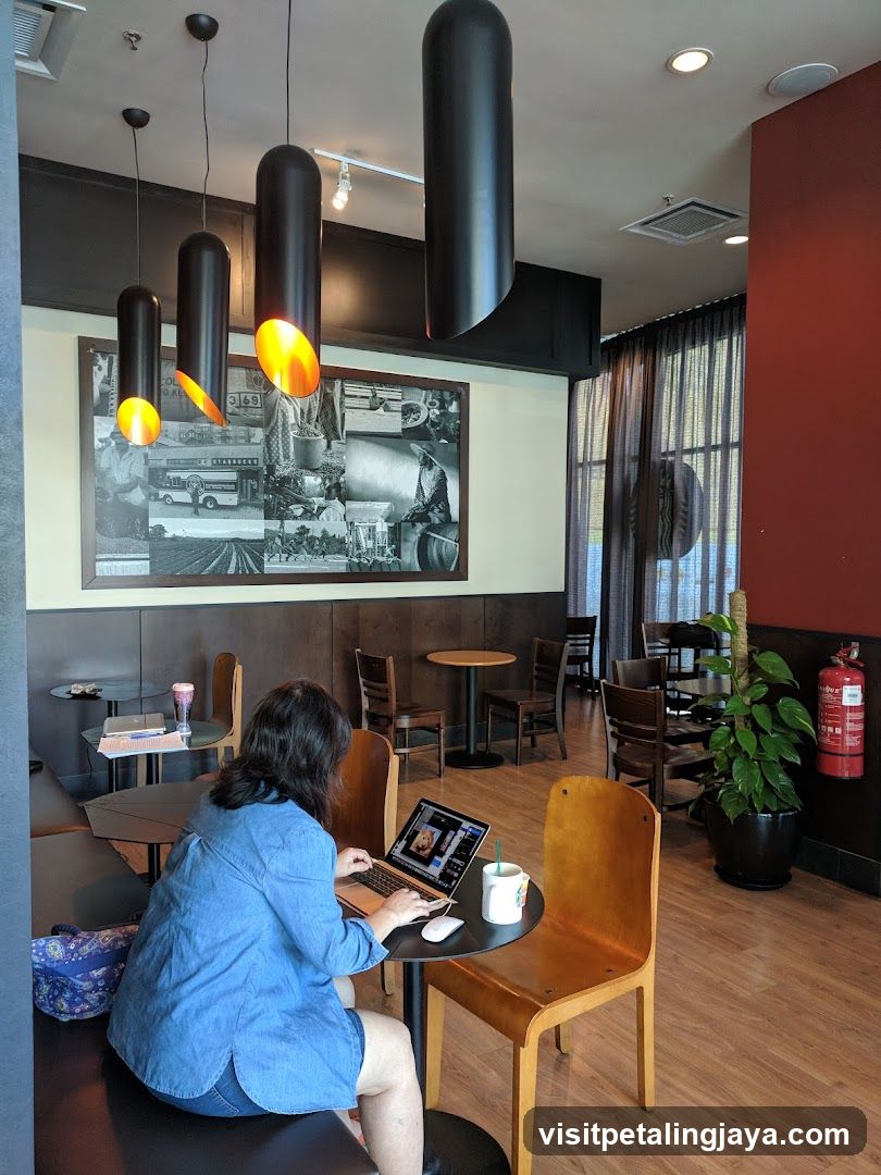 Interior of a coffee shop with customer working on laptop