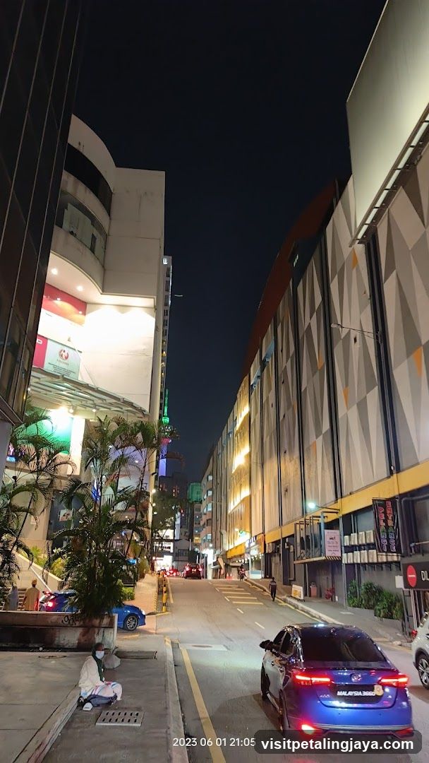 Night street scene with parked cars and illuminated buildings