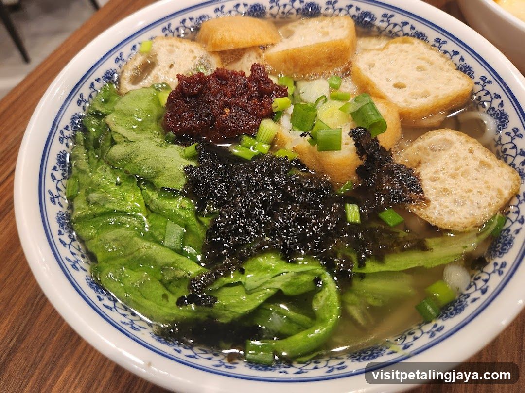 Bowl of Soup with Greens and Fried Dough