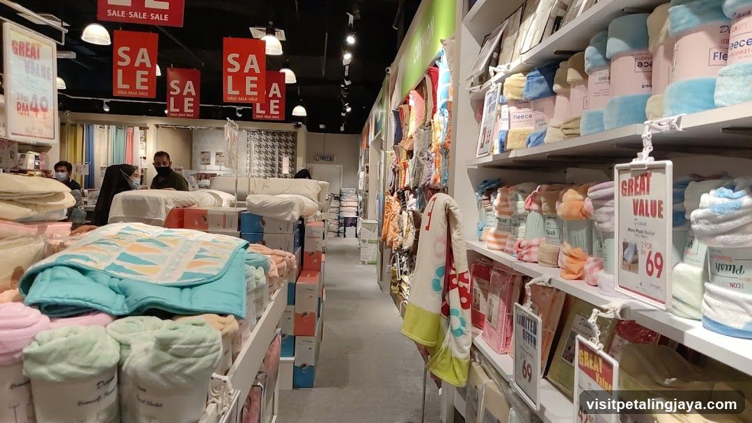 Interior of a bedding store with sale signs and shelves of towels