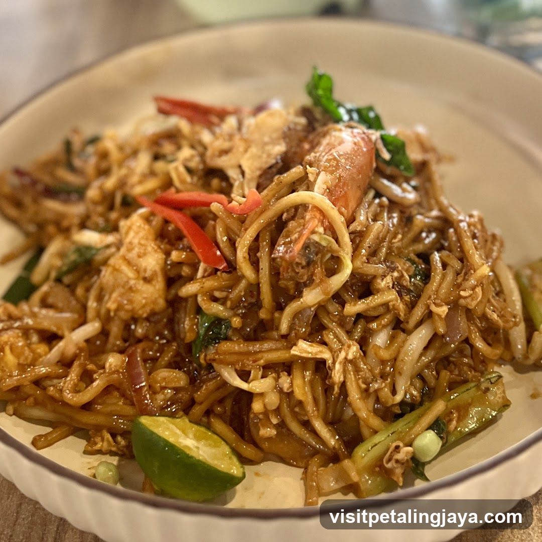 Stir-fried noodles with seafood and lime wedge