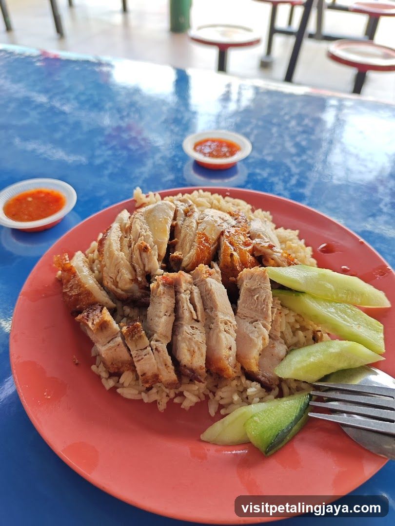 Plate of Chicken Rice with Cucumber and Chili Sauce