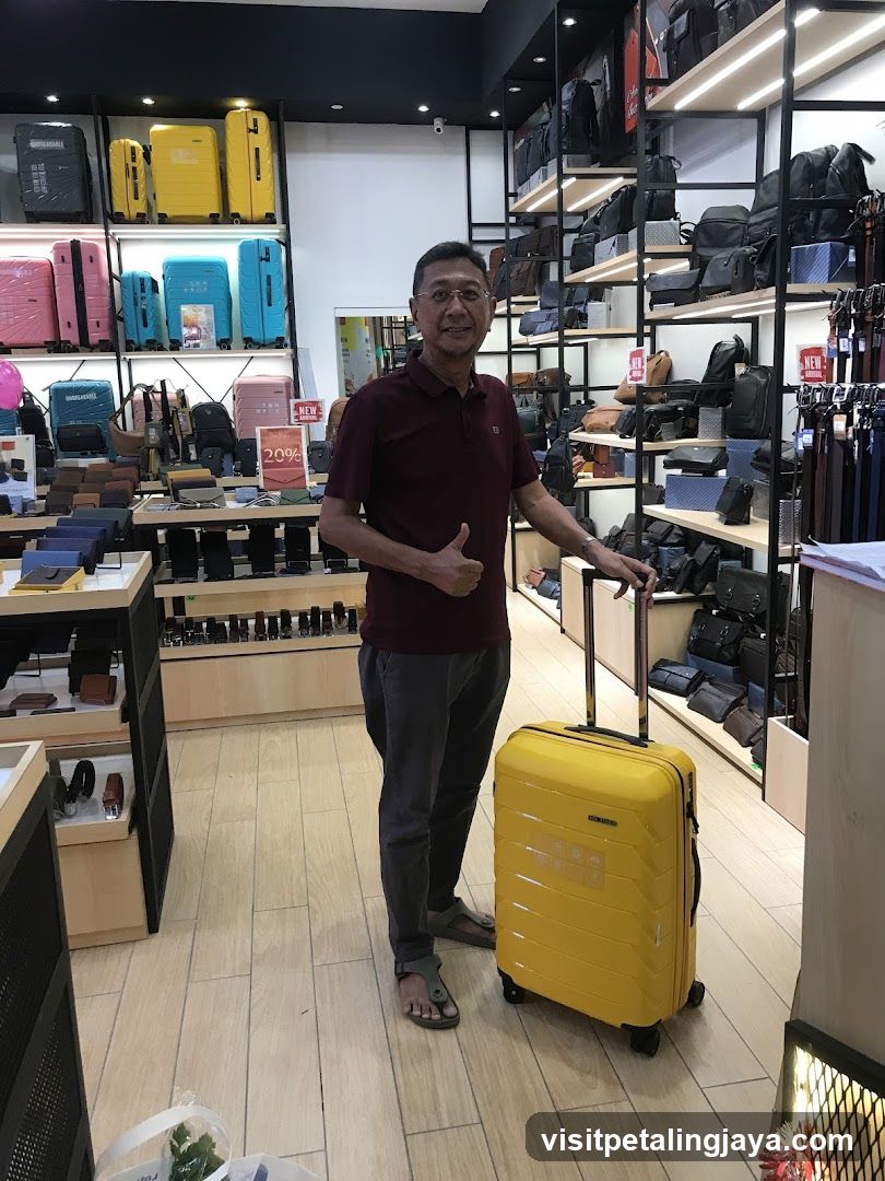 Man with yellow suitcase in luggage store