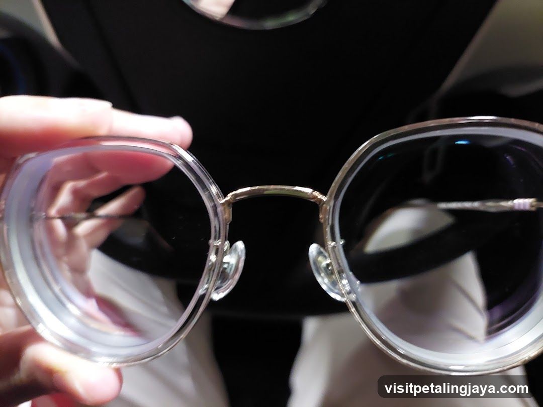 Close-up of clear-rimmed glasses held by hand