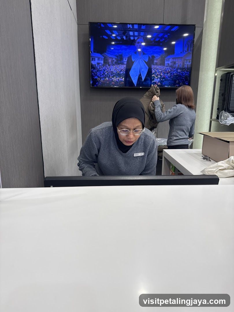 Interior of a retail or service space with staff and TV display