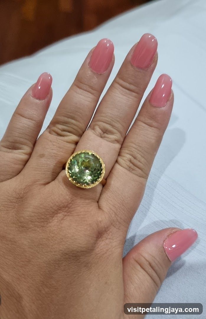 Hand with Pink Nails and Green Gemstone Ring