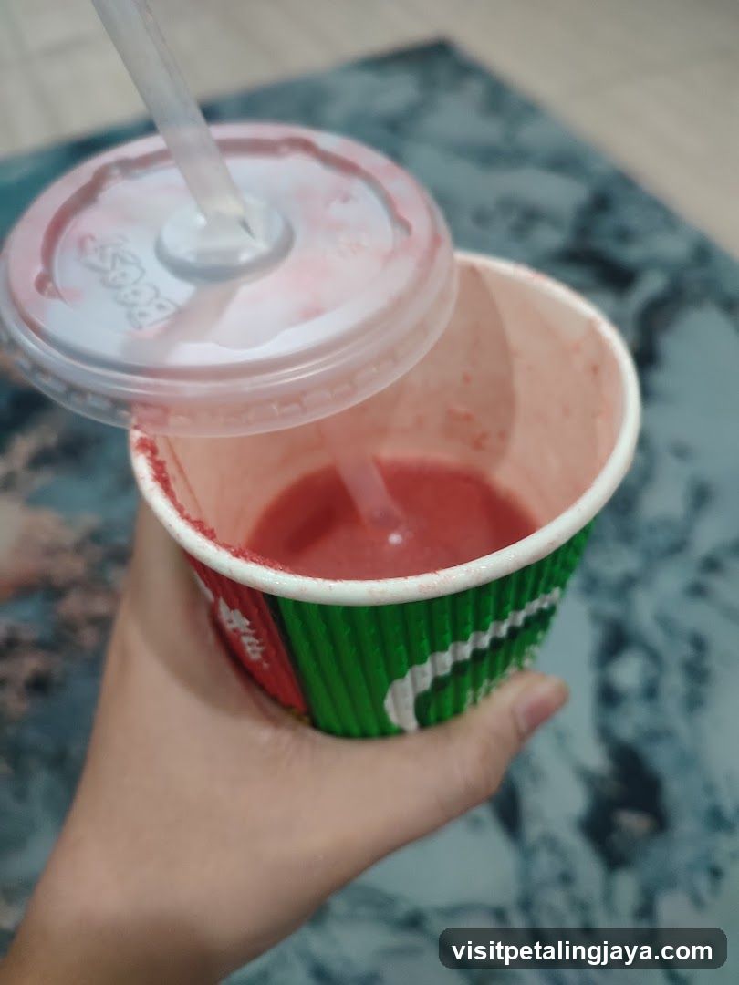 Hand holding a drink cup with lid lifted