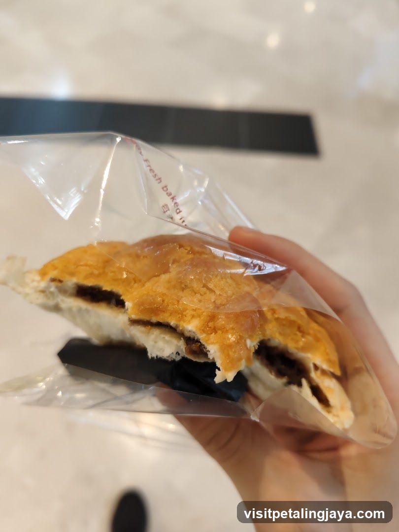 Hand holding a pastry in plastic bag
