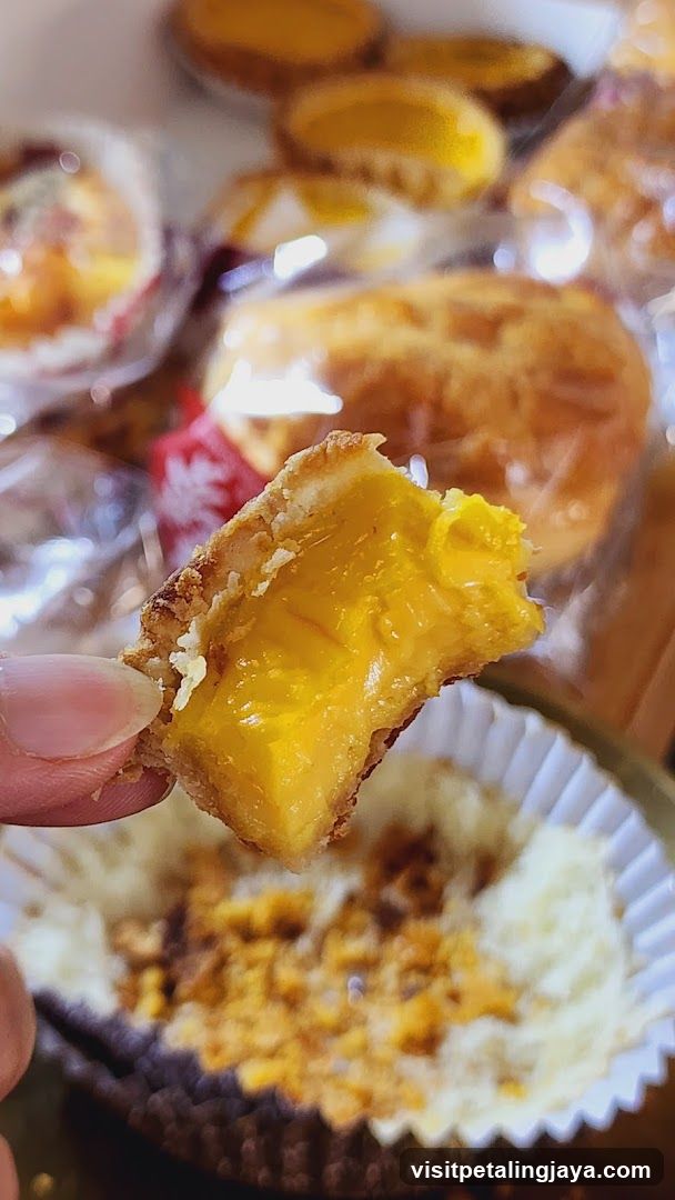 Hand Holding a Bite of Custard Tart