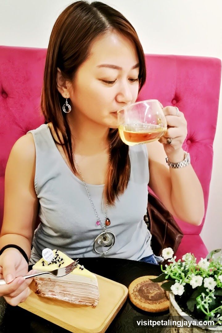 Woman enjoying tea and cake in a cozy cafe