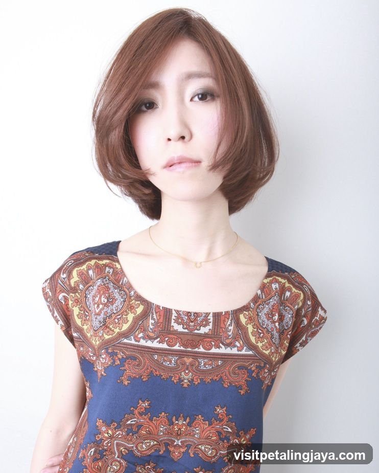 Portrait of a woman with short brown hair wearing a patterned blouse