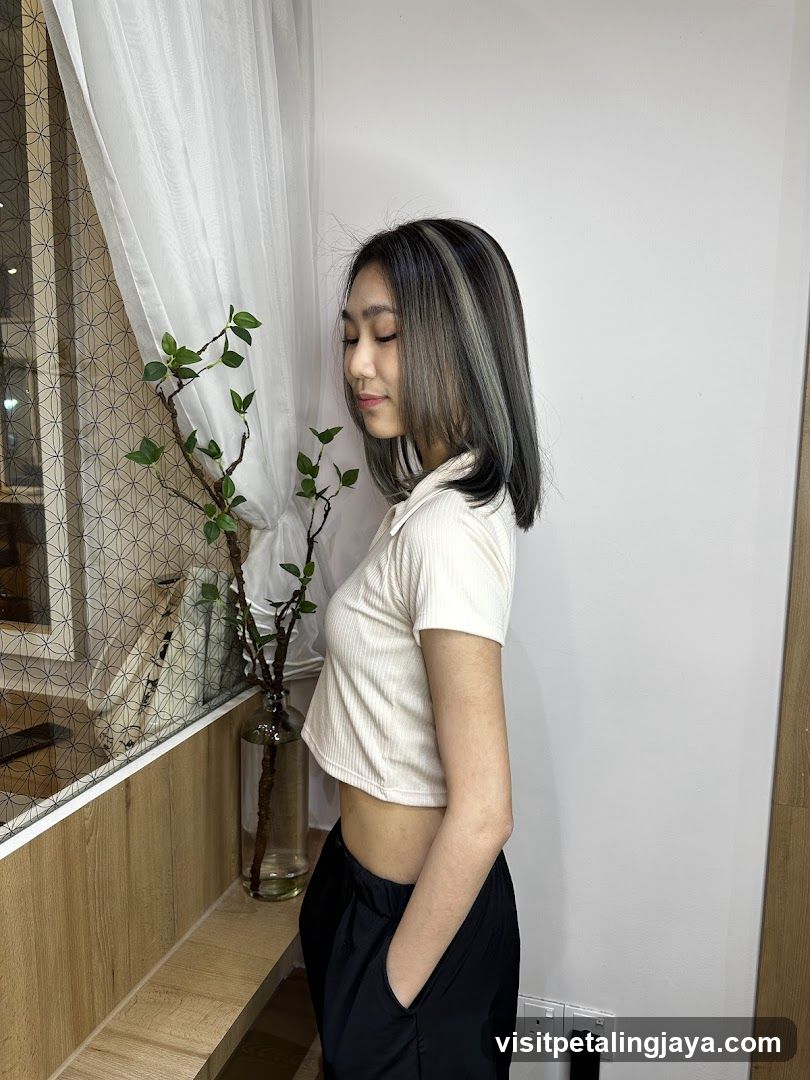 Woman with Grey Highlights Standing by Window