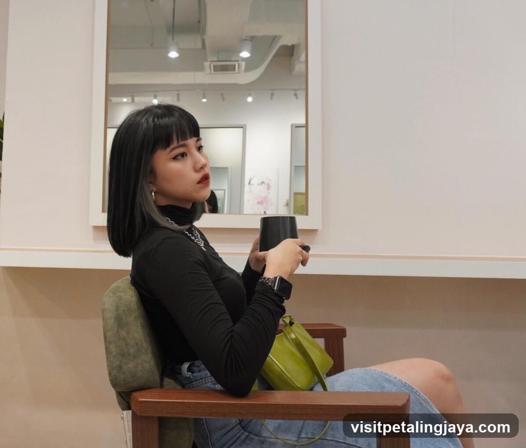 Woman in black top holding cup