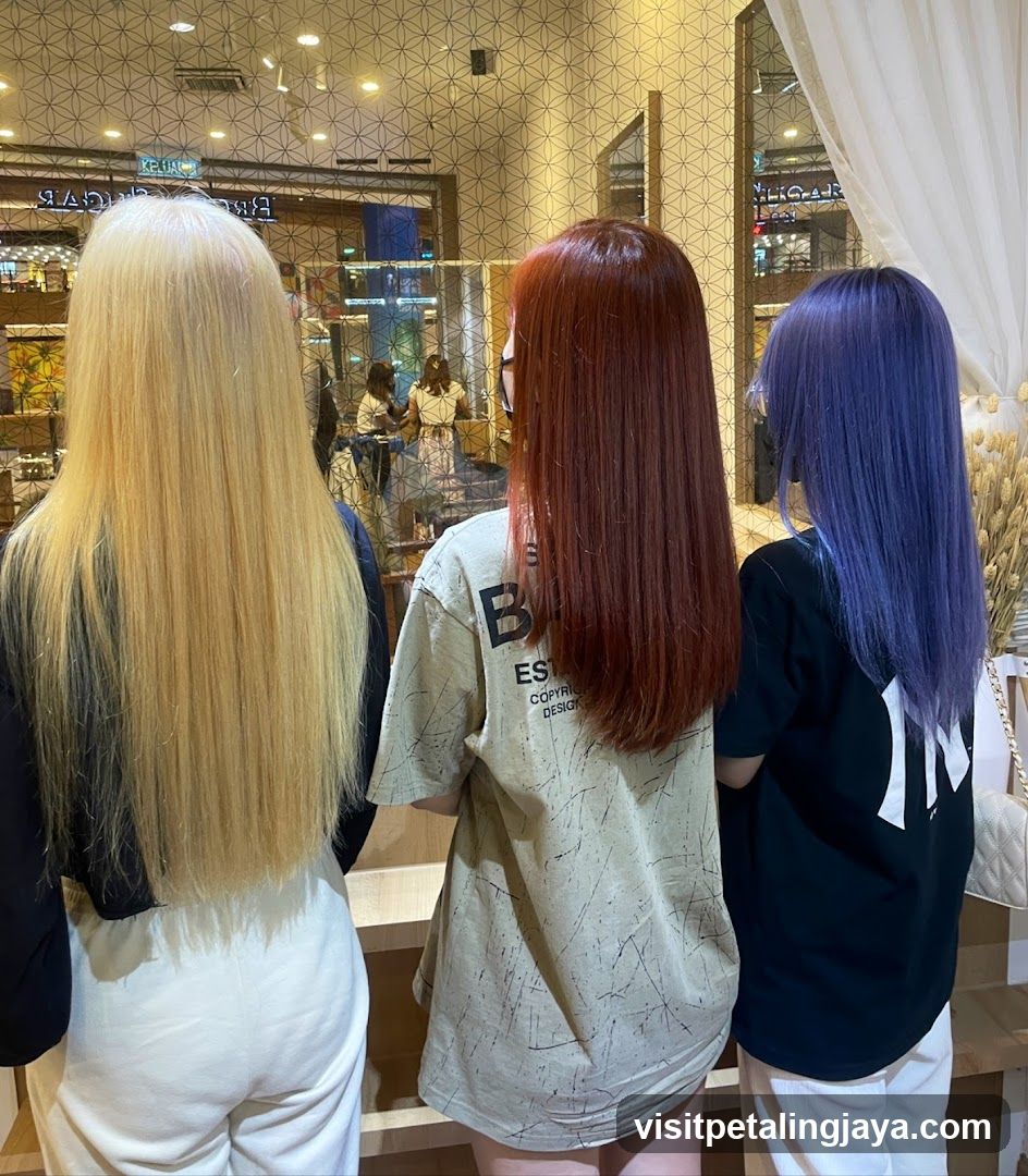 Three women with colorful hair looking into a store