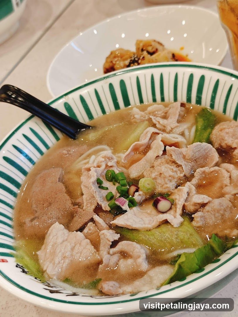 Bowl of Noodle Soup with Meat and Greens