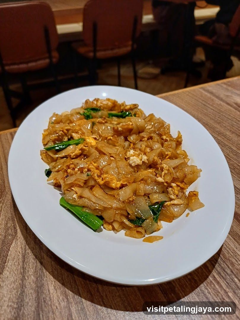Plate of Stir-Fried Rice Noodles with Egg and Greens