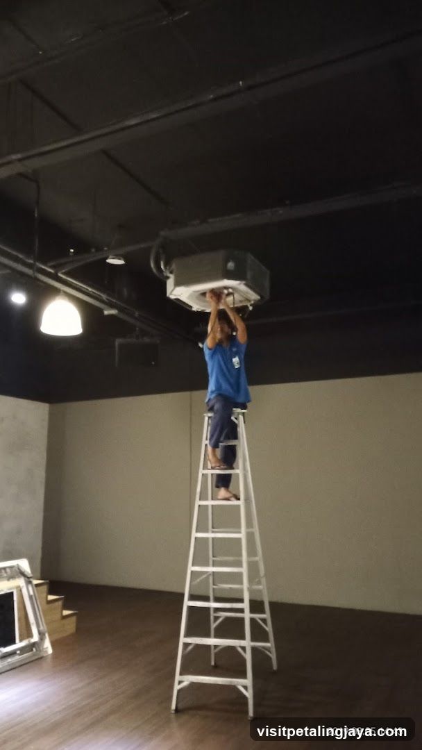 Worker installing ceiling equipment
