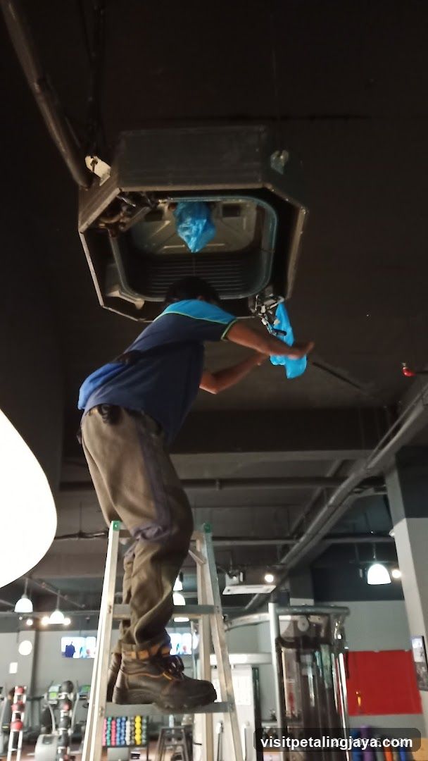 Worker Cleaning HVAC Unit in Gym Interior