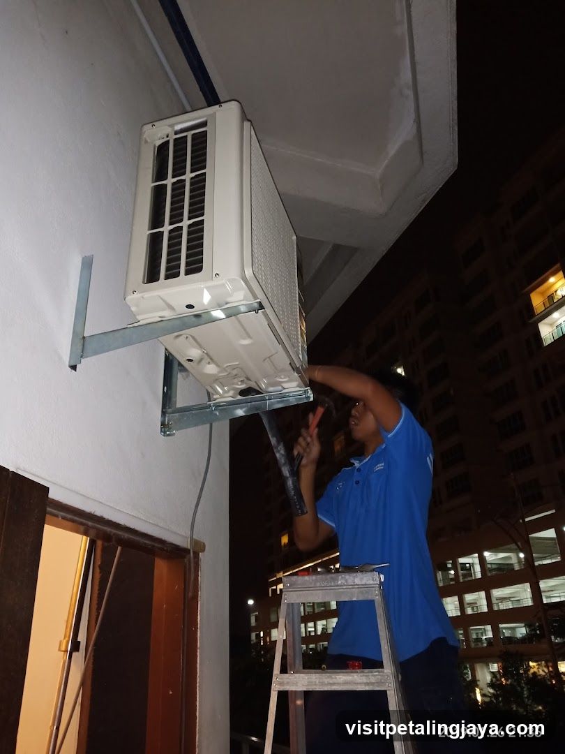Technician Installing Air Conditioner at Night