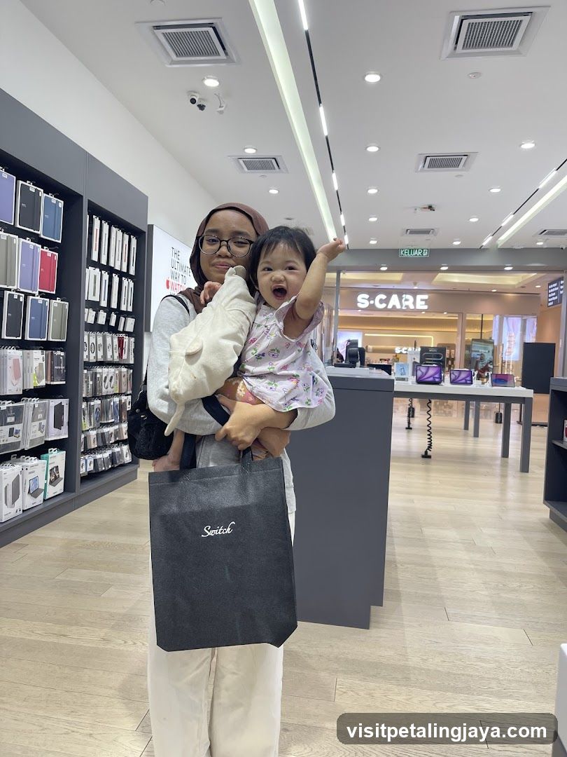 Woman holding child in electronics store