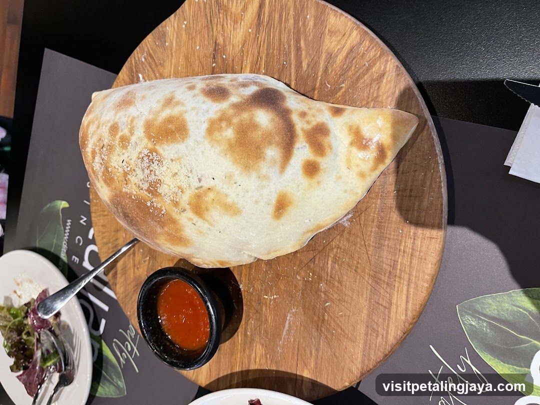Wooden Board with Calzone and Sauce