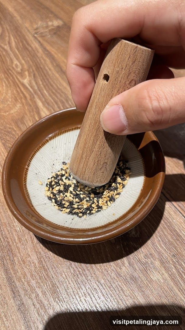 Hand grinding sesame seeds in a ceramic mortar