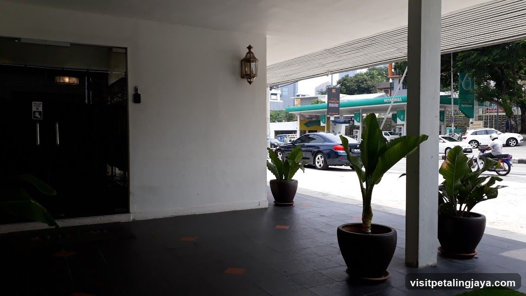 Entrance with Potted Plants and Gas Station View