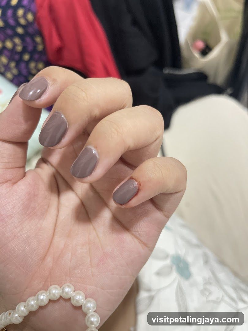 Hand with mauve nail polish and pearl bracelet