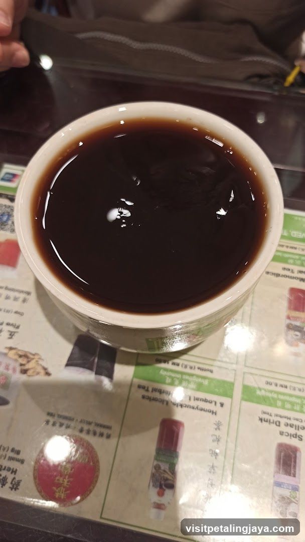 Cup of dark beverage on table