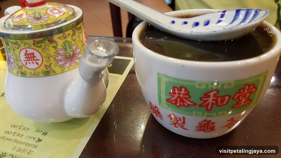 Bowl of dark soup with teapot